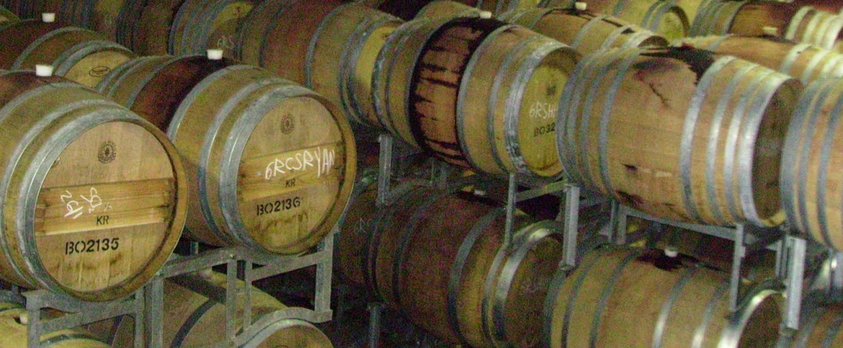 multiple wooden barrels stacked together in a room