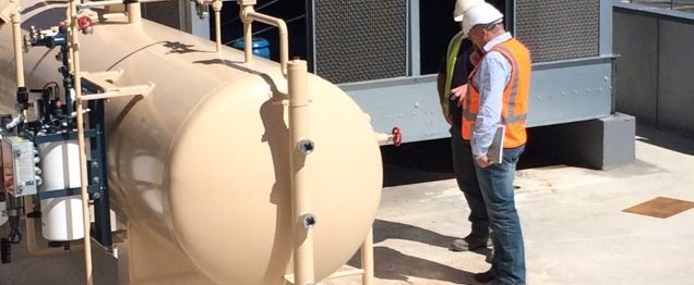 two men standing outside next to refrigeration equipment