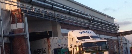 semi-truck with a Reid logo on it leaving a building