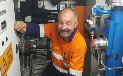 man wearing high vis workwear maintaining a marine industrial refrigeration room