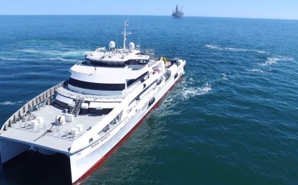 a marine vessel at sea with another marine ship in the background on the horizon