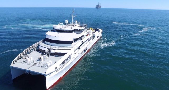a marine vessel at sea with another marine ship in the background on the horizon