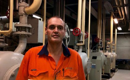 man wearing high vis workwear standing in an industrial refrigeration plantroom