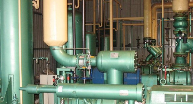 an industrial refrigeration strainer in a plant room with other equipment