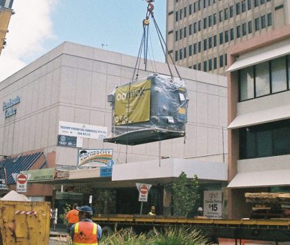 absorption chiller on a crane being carried over a building