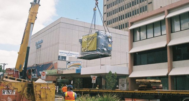absorption chiller on a crane being carried over a building