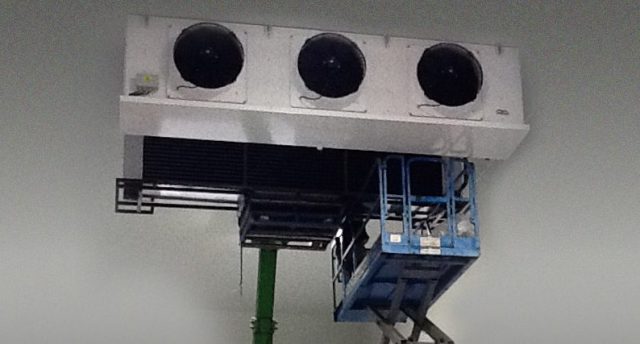industrial refrigeration equipment being lifted on a knuckle boom
