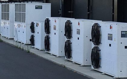 a line of eight industrial refrigeration equipment outdoors
