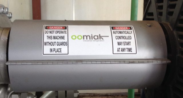 a cylindrical tank with two safety warning signs and an oomiak logo on it