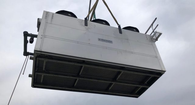 condenser being carried by a crane