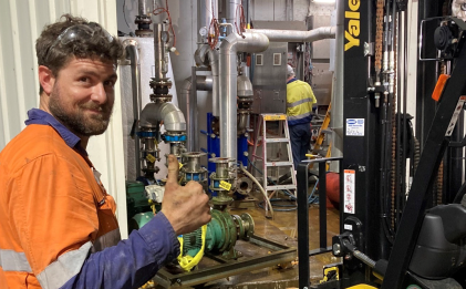man in high vis workwear in an industrial refrigeration plantroom with his thumb up