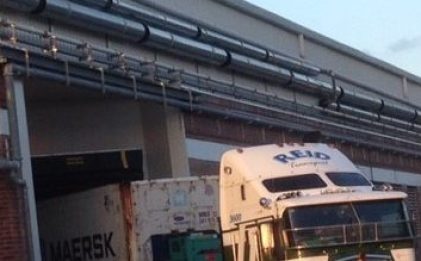 semi-truck with a Reid logo on it leaving a building