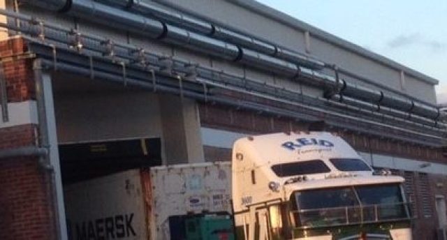 semi-truck with a Reid logo on it leaving a building