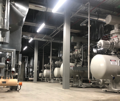 a cool room with multiple compressors and other industrial refrigeration equipment