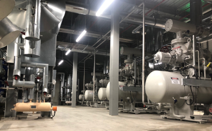 a cool room with multiple compressors and other industrial refrigeration equipment
