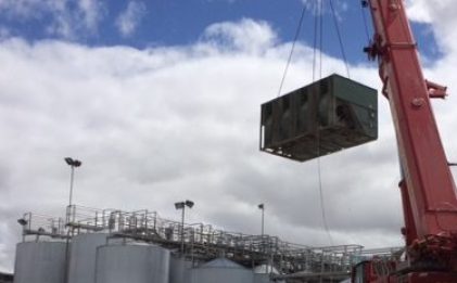 a crane carrying a evaporative condenser at a vineyard